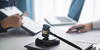 Gavel, laptop with two parties and documents